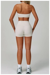 Detailed back view of beige backless yoga set featuring halter neck top and high-waist shorts