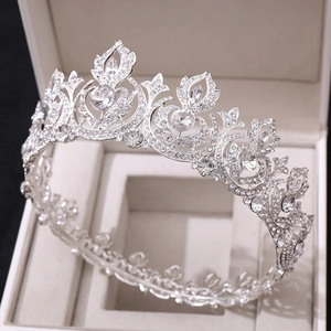 Close-up of a silver bridal crown with clear rhinestones in a beige jewelry box