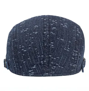 Detailed back view of dark blue denim newsboy cap featuring adjustable metal buckle