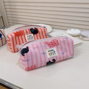 Vue détaillée de la trousse rayée en coton avec motifs de chats et écusson brodé BEST