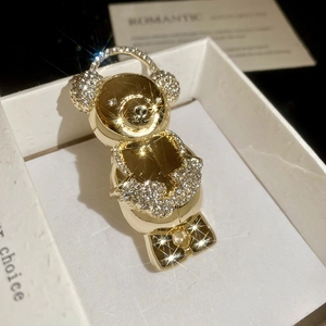 Detailed close-up of golden bear brooch with sparkling rhinestones in a gift box