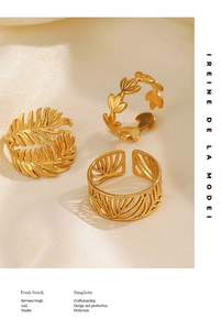 Detailed view of three gold leaf rings with intricate textures on soft silk fabric