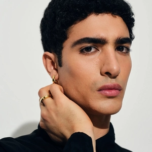 Model wearing 18k gold plated stainless steel earring and ring set on white background