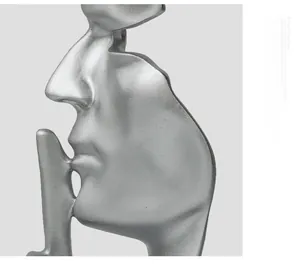 Macro detail of silver abstract sculpture showing matte texture and silence hand gesture