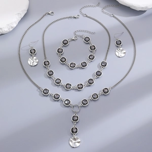 Flat lay of luxury irregular acrylic black crystal jewelry set with silver chain detail
