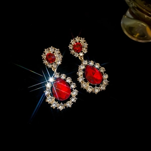 Macro shot of vintage red gemstone earrings with sparkling diamonds on gold setting