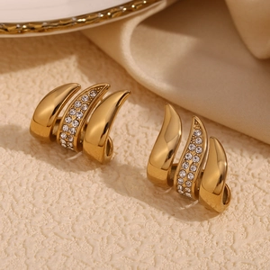 Close-up of gold-plated triple claw earrings featuring pavé-set sparkling white zircons