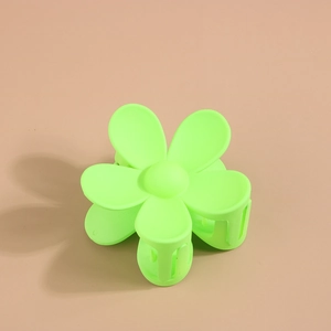 Détail macro d'une pince à cheveux fleur vert fluo avec finition mate et ressort métallique
