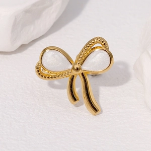 Minimalist gold bow open ring with pearl inlay on white rock texture background