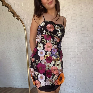 Detailaufnahme lebendiger 3D-Blumenstickerei auf einem schwarzen Mesh-Trägerkleid