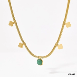 Detail of gold snake chain necklace featuring green aventurine stone and clover charms