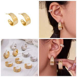 Detailed macro view of C-shaped 18k gold plated flower earrings with white zircon stones