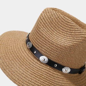 Detail of hand-woven straw hat with black leather band and embossed silver metal studs