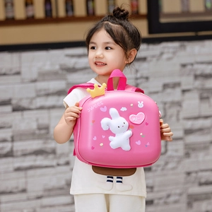 Pink toddler hardshell backpack with 3D bunny and crown worn by a child model