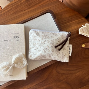Detailed macro view of a floral cotton mini pouch on a rustic wooden tray setup