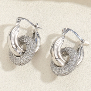 Macro shot of silver interlocking hoop earrings with micro-pave white zircon stones