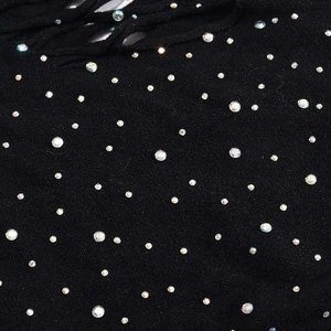 Vue macro de strass colorés sur une robe noire sans manches avec détails ajourés