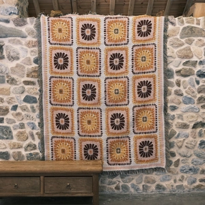 Close-up of bohemian knitted blanket texture with geometric patterns and fringe detail