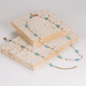 Collana dorata con perle irregolari e turchesi blu su base in pietra naturale beige
