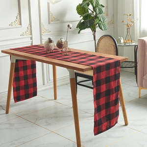 Nordic red and black buffalo plaid table runner made of polyester cotton on a wooden table