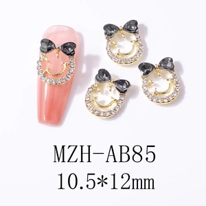 Bowtie smiley face nail art charm with black heart gem and gold alloy, 10.5x12mm size