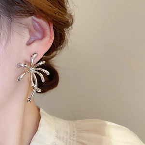 Close-up of elegant silver flower stud earring worn on model for modern style look