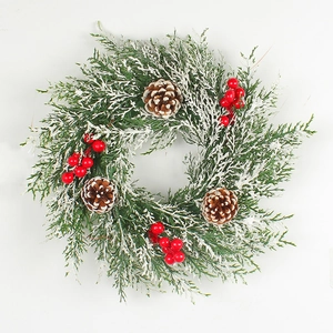 Couronne de Noël artificielle avec baies rouges, pommes de pin et aiguilles enneigées