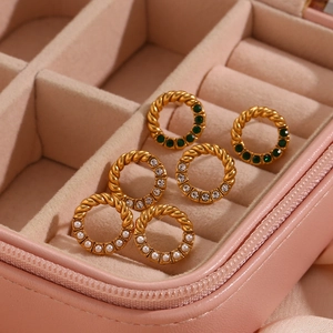 Twisted gold earrings with emerald, zircon and pearl accents in a pink jewelry box