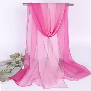 Detailed view of lightweight gradient pink chiffon scarf hanging on a metal rack display