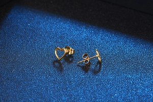 Macro detail of gold-plated hollow heart earrings showing high-quality texture and polish