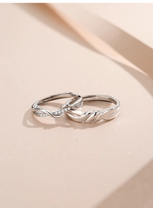 Macro shot of silver knot coupling rings with intricate textures and adjustable bands