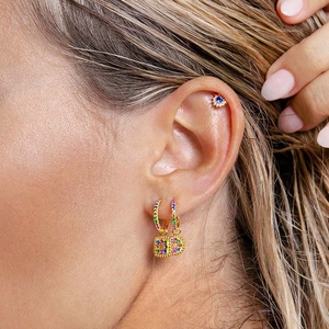 Elegant gold earrings set featuring a crystal-paved letter D and a blue sunflower ear stud