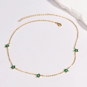 Detailed top view of gold chain necklace with five green flower charms on white background