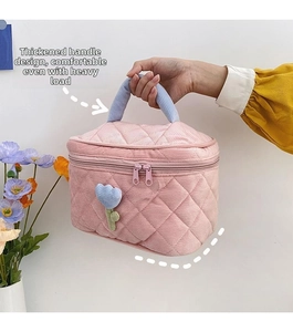 Pink quilted makeup bag detail showing the thickened blue corduroy handle for easy carrying