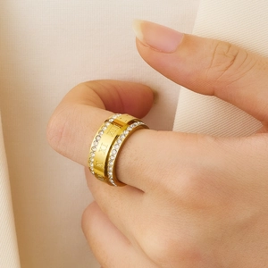 Detail of gold titanium ring with Roman numerals and crystals on a model hand