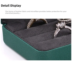 Detail showing high-end dark green leather jewelry box with multiple ring slots
