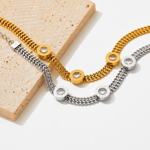 Flat snake chain bracelet in gold and silver with Roman numeral zircon pendants
