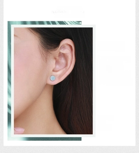 Close-up of elegant turquoise s925 silver stud earrings on female model ear