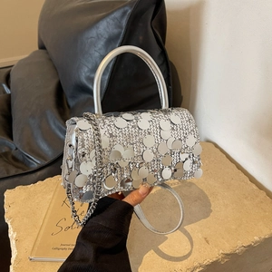 Detailed view of silver sequin bag featuring metallic chain strap and round textures