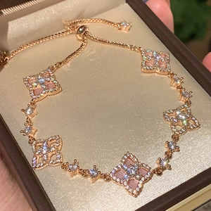 Rose gold adjustable bolo bracelet with five zircon flower charms and pink shell inserts