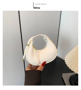 Close-up of white crescent bag with lychee grain leather and golden hardware details