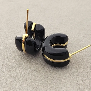 Elegant C-shaped black resin earrings with a minimalist gold line decoration