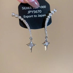 Nahaufnahme von S925 Silber Sternohrringen mit Zirkonia und gebogenen Diamantstangen