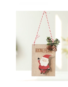 Gros plan d'une suspension de Noël en bois avec texte Buone Feste et décor de pomme de pin