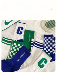 Close-up of retro checkered and striped crew socks in green and blue cotton knit