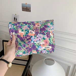 Floral cotton makeup pouch held in hand showing compact size for daily storage