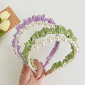 Three pleated fabric headbands with pearls in purple, green, and pink colors