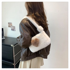 Detailed view of white faux fur shoulder bag with brown heart charm decoration