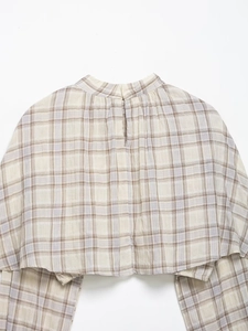 Detail of checkered plaid high neck top with back slit and fine pleated texture