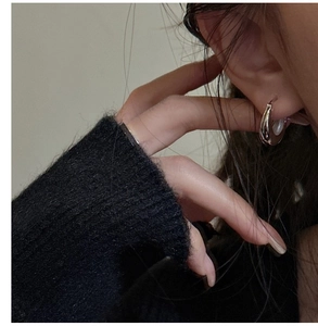 Close-up of minimalist S925 sterling silver U-shaped hoop earrings worn by a model